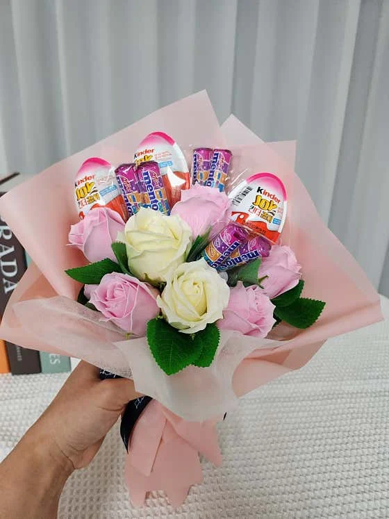 분홍색 포장에 킨더조이와 꽃을 함께 담은 꽃다발