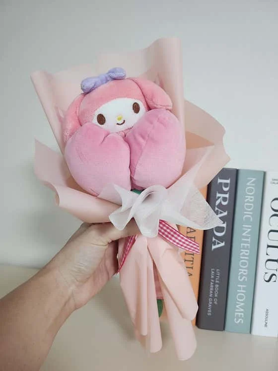 분홍색 인형과 리본으로 만든 꽃다발